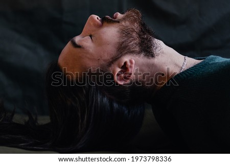 latin gay man possessed, face photo, with long hair and beard, artistic photo. green