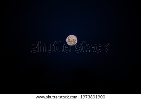 Super full moon in the middle of a dark sky background