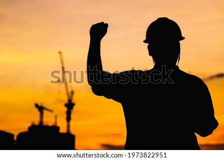 The silhouettes of a male engineer or a businessman survey the work of multi-storey buildings and blurred construction. Building inspection concept

