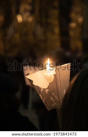 Night scene of a candle in a Holy Week procession, with the church's altar out of focus in the background. Concept of Christianity Royalty-Free Stock Photo #1973841473