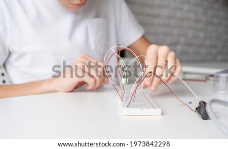 boy working with LED lights on experimental board for science project