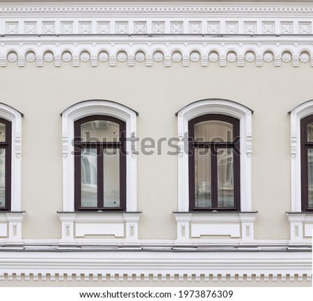Vintage architecture classical facade building. Windows framed in architectural  Russian style decor. Front view.