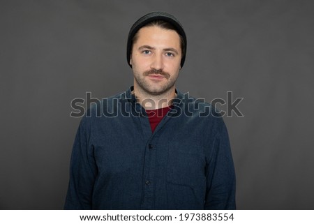 Portrait of young hipster guy in hat isolated on grey background. Copy space. Kind friendly stylish man looks at camera. Concept of advertising message, fashion, male beauty, offer, own experience