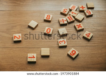 Selective focus of wooden numbers and four basic operations of elementary arithmetic. Royalty-Free Stock Photo #1973901884