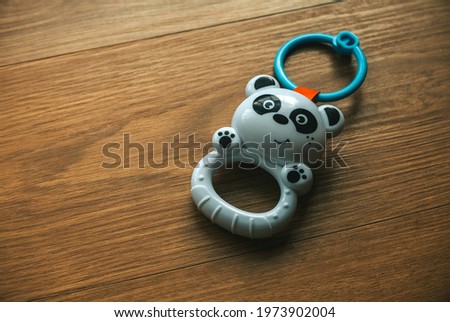 Panda baby rattle toy isolated on a wooden background.