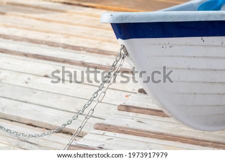 the bow of the boat with chains close-up on the background of the wooden floor on a sunny warm day