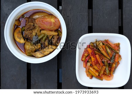 Selective focus picture of meat dalca and spicy "acar" vegetable on wooden table. Famous South East Asia during festive and Eid Mubarak.
