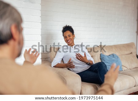 Smiling black woman talking to her male friend.