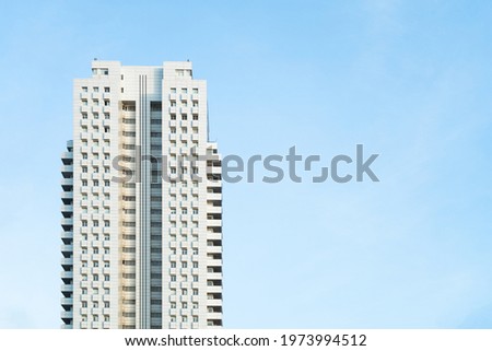 Front view of a white modern skyscraper perfect symmetry with blue sky and copy space. Architecture background concept Royalty-Free Stock Photo #1973994512