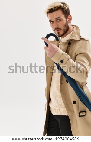 a man in a coat with an umbrella in his hands accessories male style studio