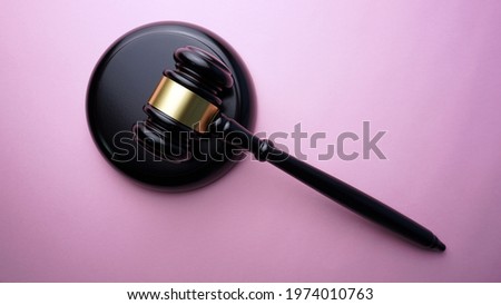 Wooden judge gavel on a pink background. Copy space for text. Legal action concept.
