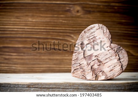 Bark heart on wooden background. Studio photography.