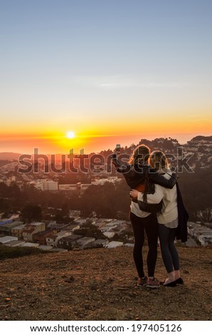 Two girls taking a selfie at the sunset