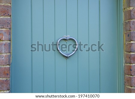 Love heart on a blue door with a brick boarder