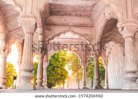 Small palace at the Red fort of Delhi, India. A shining white marble palace with cylindrical pillars and arches in traditional Mughal pattern of architecture. Royalty-Free Stock Photo #1974206960
