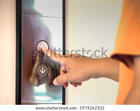 The finger of male pressing the elevator or lift button for next level up in apartment or condominium. More advance to success concept.