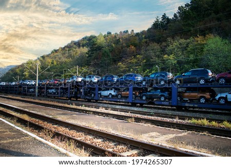 Train transporting cars.Autorack with new cars for export. Royalty-Free Stock Photo #1974265307