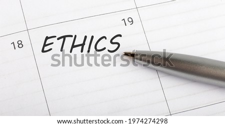 Text ETHICS on calendar planner to remind you an important appointment with pen on isolated white background.