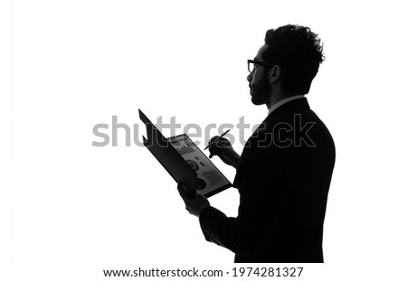 Silhouette of arabian businessman holding document file.