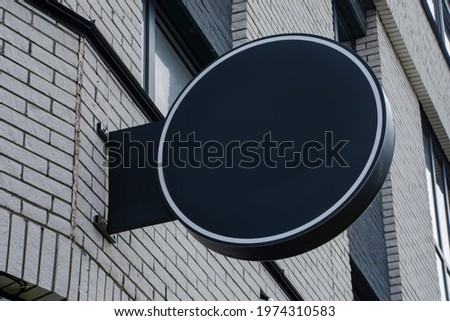 Mock-up of a round street signboard for outdoor advertising on the background of the house
