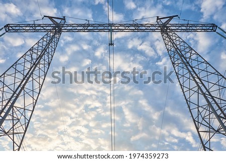 Electric poles on sky background. Clouds in the blue sky. Bottom view. World Environment Day.