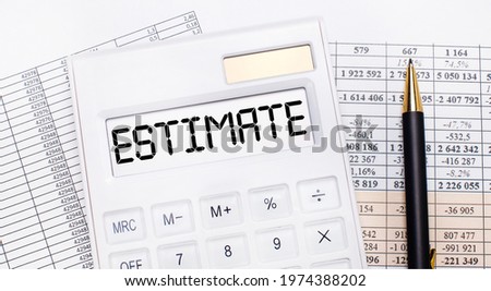 On the desktop there are reports, a white calculator with the text ESTIMATE on the scoreboard and a pen. Business concept.