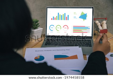 Close-up,Business woman using laptop for report data from chart dashboard, Sending financial information at modern business cafe. Work from home or freelance concept. Business investment leader.