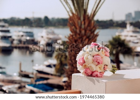 Bridal bouquet on a background of palm trees and pier with yachts