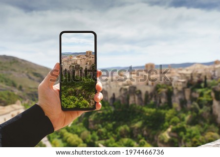 Horizontal view of unrecognizable man taking a picture with her phone of a travel destination in Europe. Technology, tourism and holidays concept in the spanish city of Cuenca.