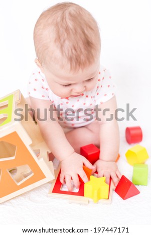 Cute baby girlplaying on a white blanket.