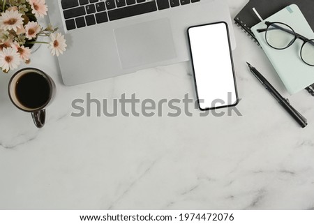 Smart phone, laptop computer, notebook and coffee cup on marble background.