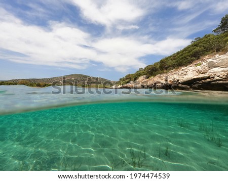 Underwater split photo of beautiful sandy bay of Shinias, Attica, Greece