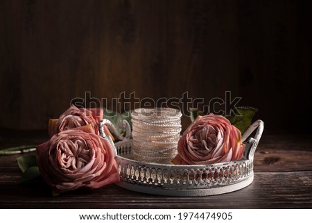 Three roses in Old Rose' colors lie on the wooden background. Vintage style, landscape format. Fits well for the postcards, background. Still life.