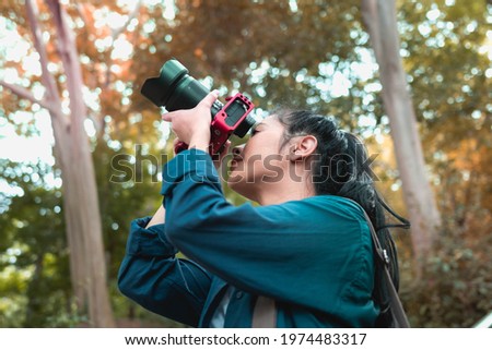 
Young Asian women taking nature photos in the forest area.
