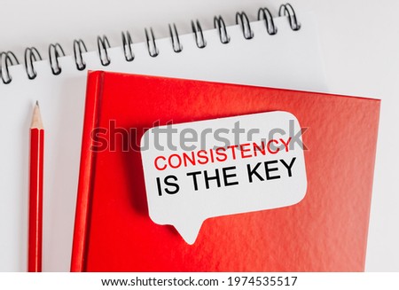 Text Consistency is the key on a white sticker with office stationery background. Flat lay on business, finance and development concept
