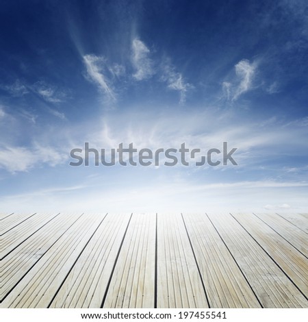 Wooden floor leading to bright sky 