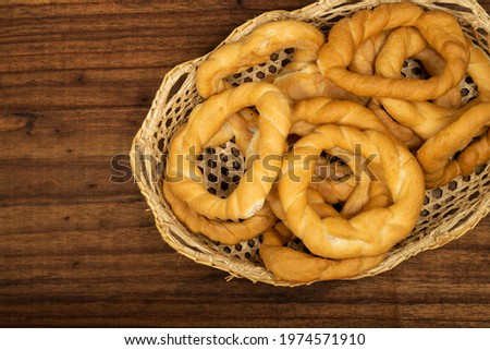 Pieces of traditional Latin American pastry called ROSQUITAS DE SAL or ROSCAS made with wheat flour. Top view of Neapolitan cookies called TARALLI. Stale salt bagels. Wood table. Ecuador