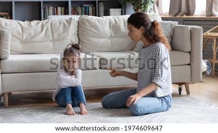 Strict young Caucasian mother talk lecture ill-behaved stubborn small preschooler daughter at home. Serious mom scold unhappy naughty little girl child kid. Family fight, generation gap concept. Royalty-Free Stock Photo #1974609647