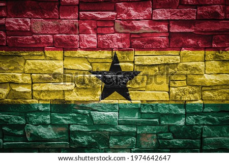National flag of Ghana on stone  wall background.The concept of national pride and symbol of the country. Flag  banner on  stone texture background.