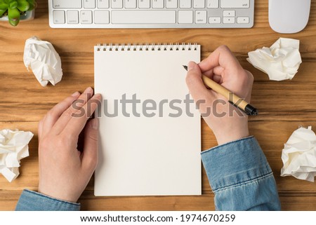 Overhead photo of blank notepad paper hands pen plant computer keyboard and mouse isolated on the wooden backdrop