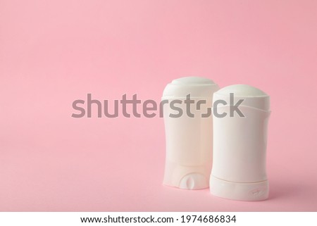 White antiperspirant deodorant on pink background. Skin care concept. copy space, top view.