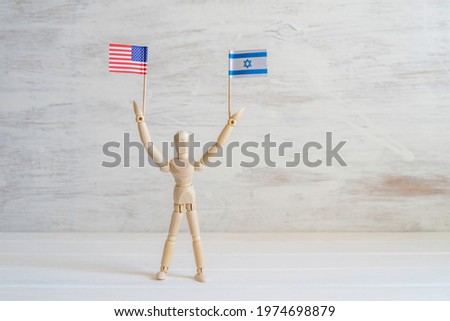Wooden man figure with American and Israeli flags on white background with copy space.