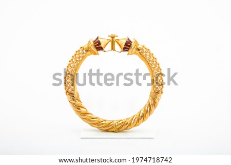 Golden bangle with beautiful work close view ideal for wedding isolated on white background. Gold jewellery stock photo. Royalty-Free Stock Photo #1974718742