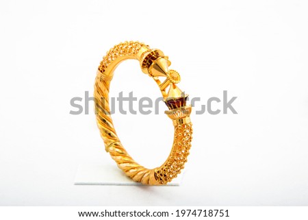 Golden bangle with beautiful work close view ideal for wedding isolated on white background. Gold jewellery stock photo. Royalty-Free Stock Photo #1974718751