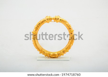 Golden bangle with beautiful work close view ideal for wedding isolated on white background. Gold jewellery stock photo. Royalty-Free Stock Photo #1974718760