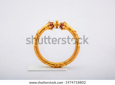 Golden bangle with beautiful work close view ideal for wedding isolated on white background. Gold jewellery stock photo. Royalty-Free Stock Photo #1974718802
