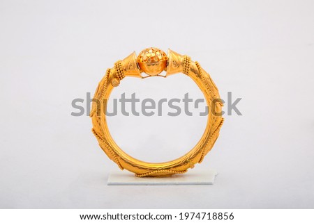 Golden bangle with beautiful work close view ideal for wedding isolated on white background. Gold jewellery stock photo. Royalty-Free Stock Photo #1974718856