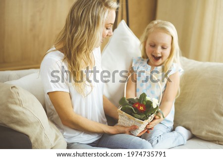 Happy mother day. Child daughter congratulates mom and gives her basket of spring flowers. Family and childhood concepts