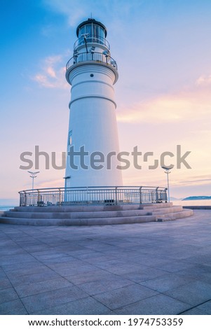 A beautiful lighthouse is a landmark building along the coast of Qingdao, Shandong Province, China Royalty-Free Stock Photo #1974753359