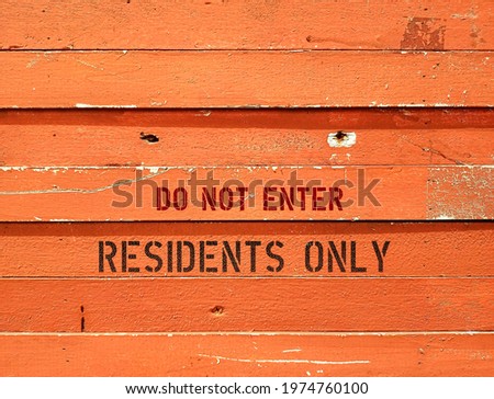 Orange wall background with text inscription DO NOT ENTER - RESIDENTS ONLY  - residents and tenants privacy protection sign to prevent unwanted visitors in around apartment condominium or private area